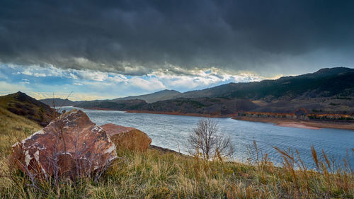 Scenic view of lake by mountains against sky