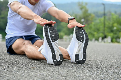 Low section of woman exercising on road