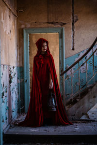 Portrait of woman standing against wall in building