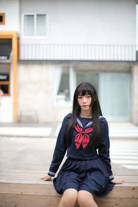 Portrait of young woman sitting outdoors