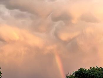 Low angle view of rainbow against cloudy sky