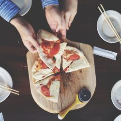 Directly above view of women eating pizza at restaurant