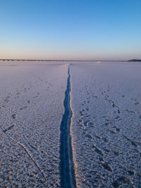 Scenic view of land against clear sky during winter