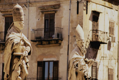 Low angle view of statue against historic building