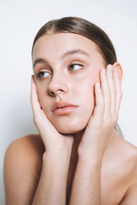 Close up beauty portrait of young girl with fresh skin tone on white background