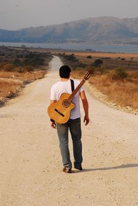 Rear view of man standing on the road