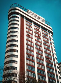 Low angle view of modern building against clear blue sky