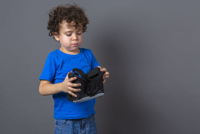 Photo of curly-haired caucasian boy wearing virtual reality glasses