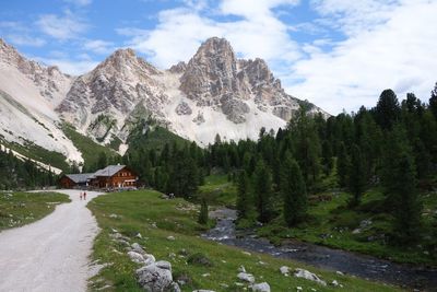 Scenic view of stream by mountains against sky