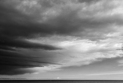 Scenic view of sea against storm clouds