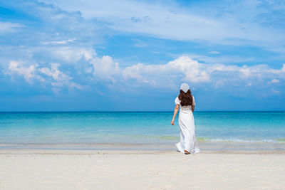 Woman on beach against sky