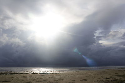 Sunlight streaming through clouds over sea