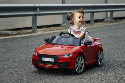 A girl riding a toy car