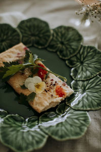 Cracker with herbs and edible flower on plate