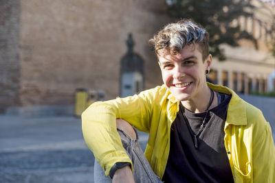 Portrait of a non binary person looking at camera while posing outdoors. person