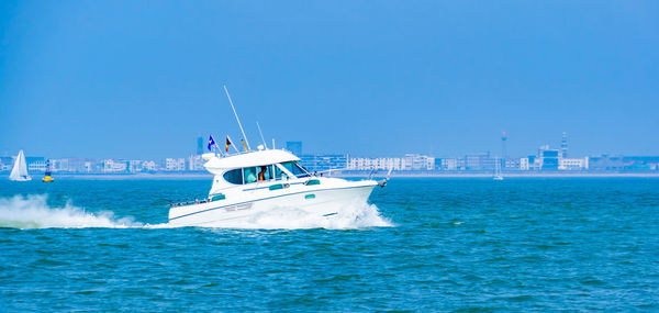 Ship sailing in sea against clear blue sky