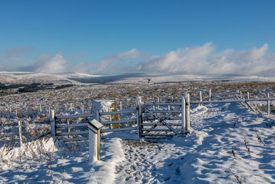 Snow covered land against blue sky