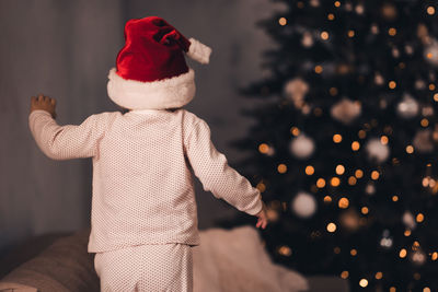 Rear view of girl looking at christmas tree