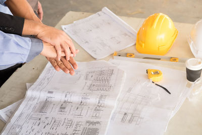 High angle view of man holding paper on table