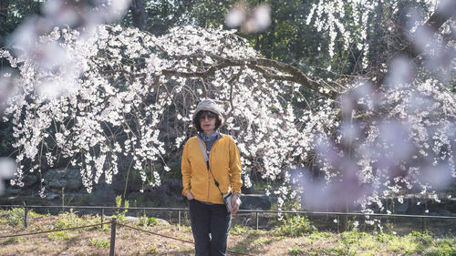 Rear view of woman standing against trees