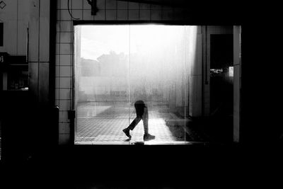 Person seen through wet window during rainy season