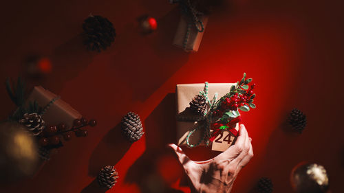 Boy is placing a beautiful christmas box on red table