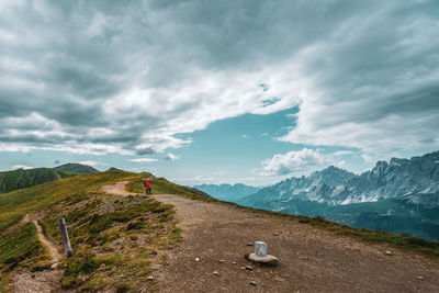 Backpacker on hiking trails in the dolomites, italy.