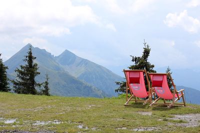Two empty lounge chairs on top of the mountain