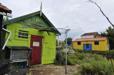 Houses by street against sky