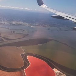 Cropped image of airplane wing over landscape