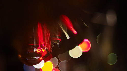 Close-up of hand holding illuminated lights at night