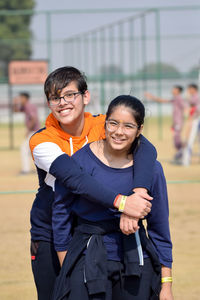 Portrait of smiling brother and sister standing in park