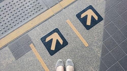 Low section of man with text on road