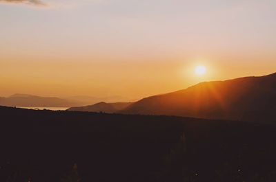 Scenic view of silhouette mountains against sky during sunset