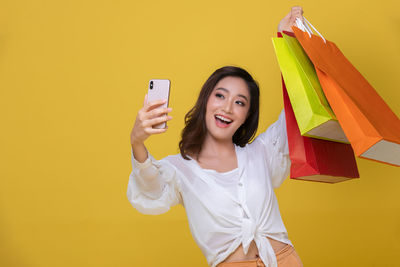 Smiling young woman using mobile phone outdoors