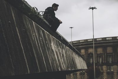 Low angle view of man on built structure