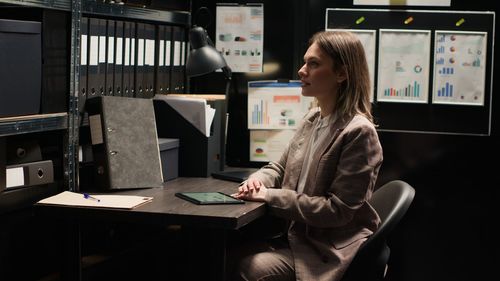 Side view of young woman sitting on table