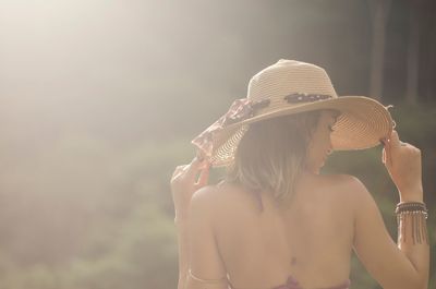 Rear view of woman wearing hat in summer