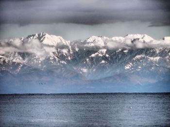 Scenic view of sea and mountains against sky