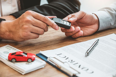 Midsection of man using mobile phone on table