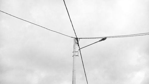 Low angle view of electricity pylon against sky