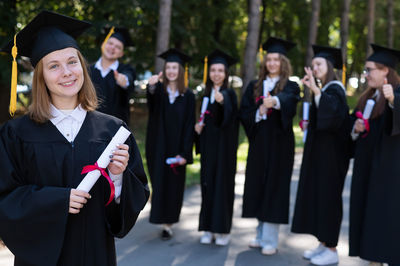 Portrait of students wearing graduation gown