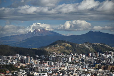 Aerial view of townscape and mountains against sky