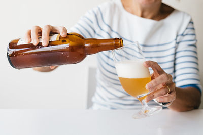 Woman pouring a refreshing beer in a glass.