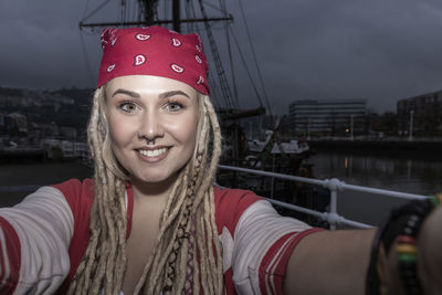 Pretty blonde woman with dreadlocks smiling while taking a selfie