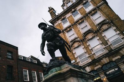 Low angle view of statue against building in city