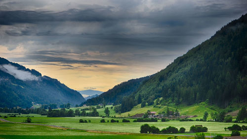 Scenic view of green landscape and mountains against sky