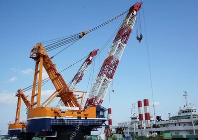 Low angle view of crane against sky