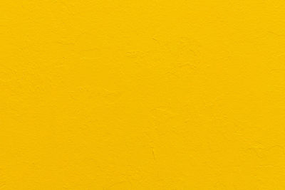 Abstract bright yellow painted full frame  wall background