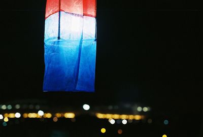 Multi colored illuminated lights against blue sky at night